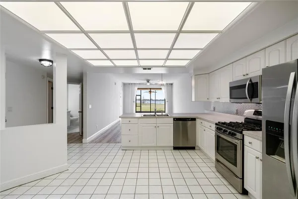 a large kitchen with a stove top oven cabinetry and a refrigerator