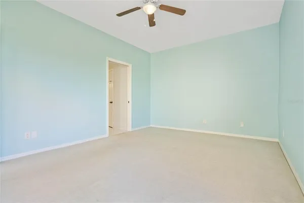 an empty room with a chandelier fan