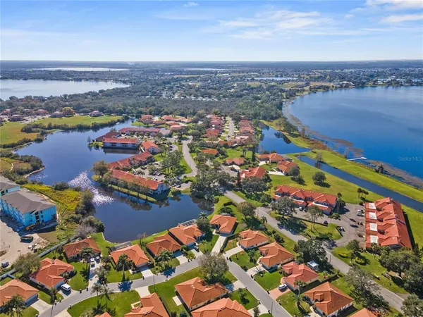 an aerial view of city and lake with trees all around
