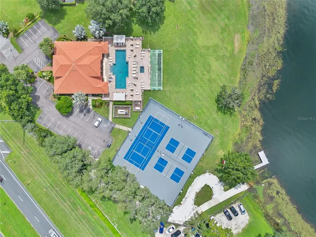 an aerial view of residential house with outdoor space and trees all around