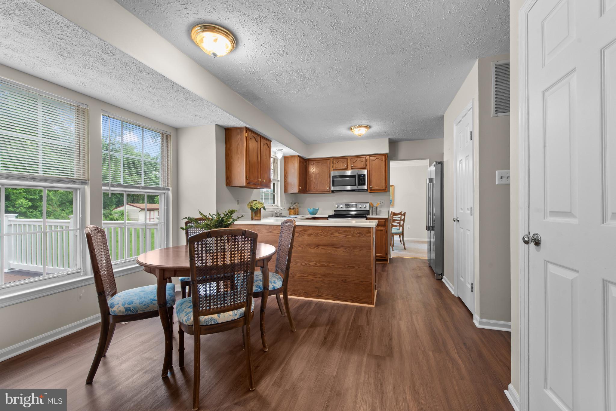 3107 Pouska Road Abingdon, MD 21009 - Photo 13 of 38 a kitchen with stainless steel appliances granite countertop a dining table chairs refrigerator and sink