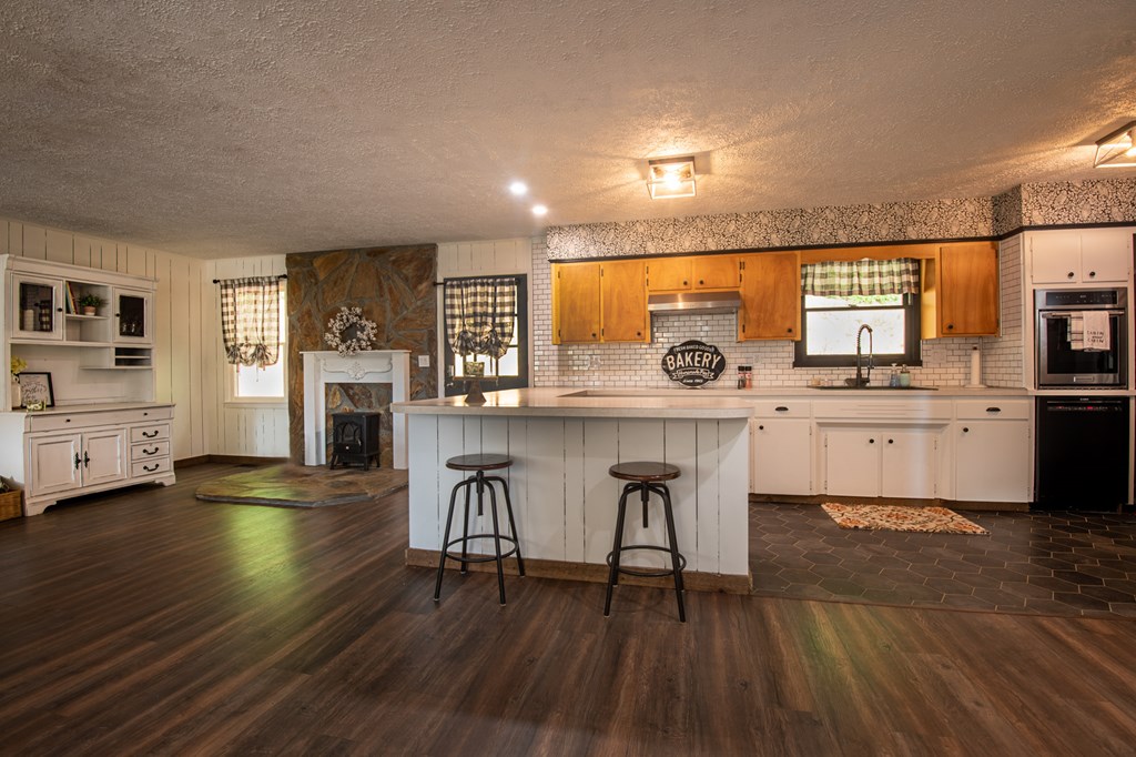 588 Pinetree Road Blue Ridge, GA 30513 - Photo 7 of 54 a kitchen with stainless steel appliances a kitchen island hardwood floor sink stove dining table and chairs