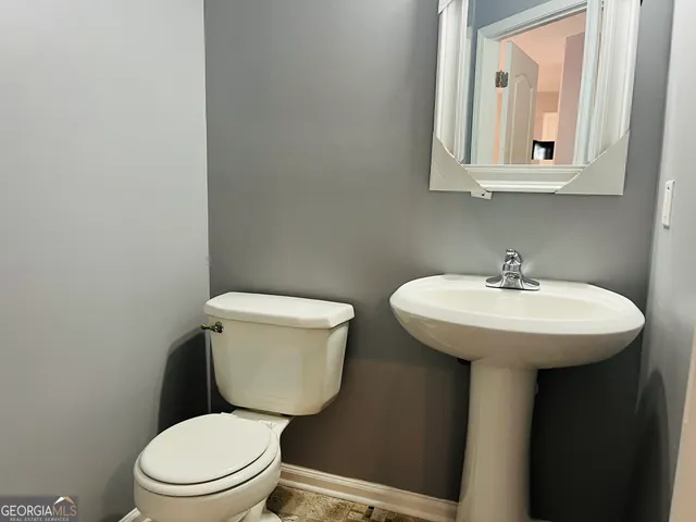 a bathroom with a toilet a sink and mirror