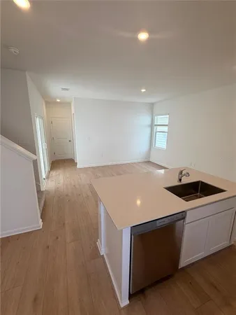 a kitchen with a wooden floor and white cabinets