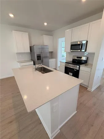 a kitchen with stainless steel appliances a stove a sink a microwave and a refrigerator