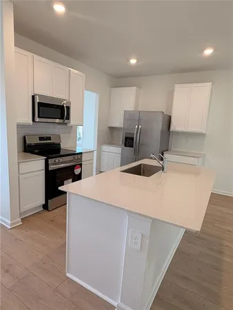 a kitchen with kitchen island a stove a sink and a refrigerator