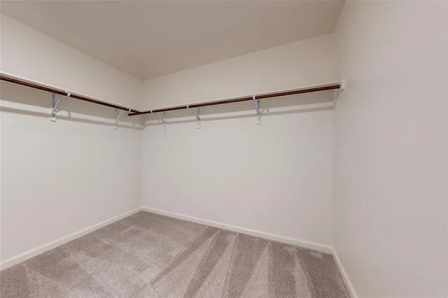 an empty room with a window and a ceiling fan