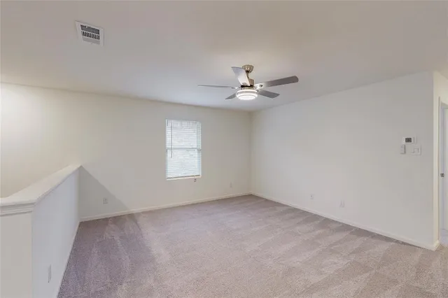 an empty room with a window and a ceiling fan