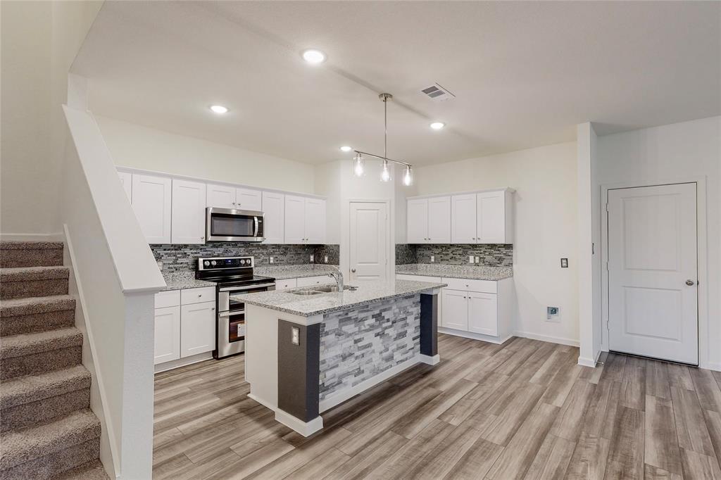 417 Madison Way Princeton, TX 75407 - Photo 8 of 40 Kitchen with backsplash, stainless steel appliances, light stone counters, white cabinets, and recessed lighting