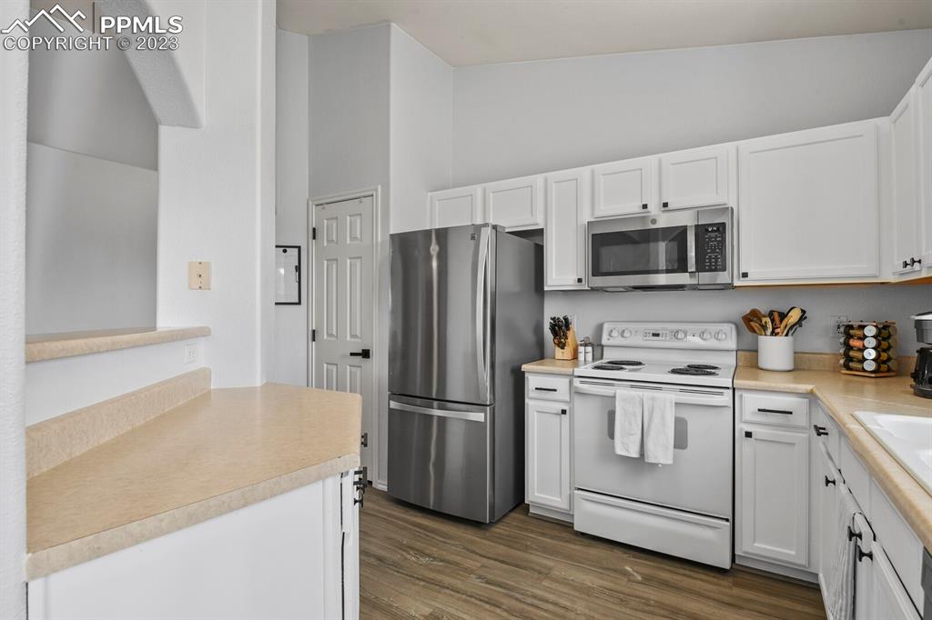 3960 Riviera Grove, Unit 204 Colorado Springs, CO 80922 - Photo 11 of 25 a kitchen with a sink a stove a refrigerator and cabinets