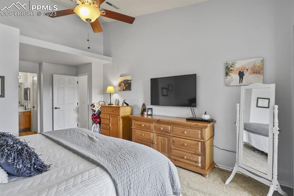 3960 Riviera Grove, Unit 204 Colorado Springs, CO 80922 - Photo 16 of 25 a bedroom with a bed and a chandelier