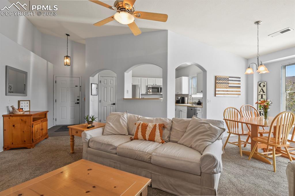 3960 Riviera Grove, Unit 204 Colorado Springs, CO 80922 - Photo 6 of 25 a living room with furniture kitchen view and a chandelier