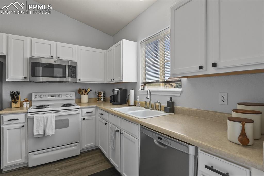 3960 Riviera Grove, Unit 204 Colorado Springs, CO 80922 - Photo 10 of 25 a kitchen with appliances a sink and cabinets