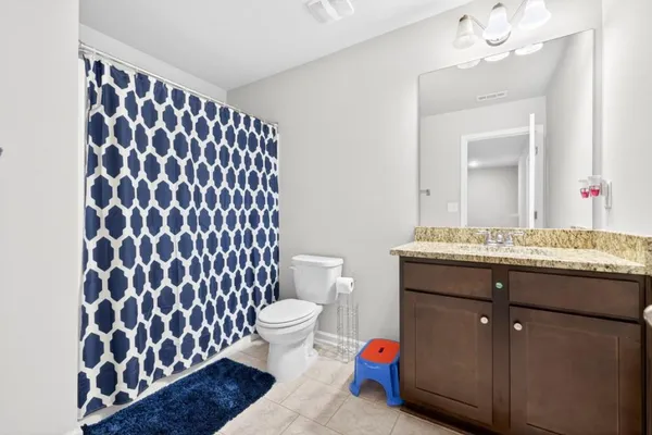 a bath room with a toilet a sink and a mirror