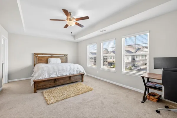 a bedroom with a bed chair and a large window