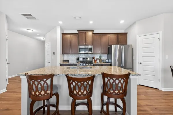 a kitchen with a dining table chairs refrigerator and cabinets