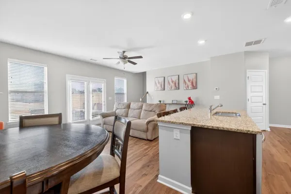 a living room with granite countertop furniture and a wooden floor