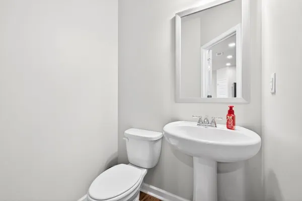 a bathroom with a sink a toilet and mirror