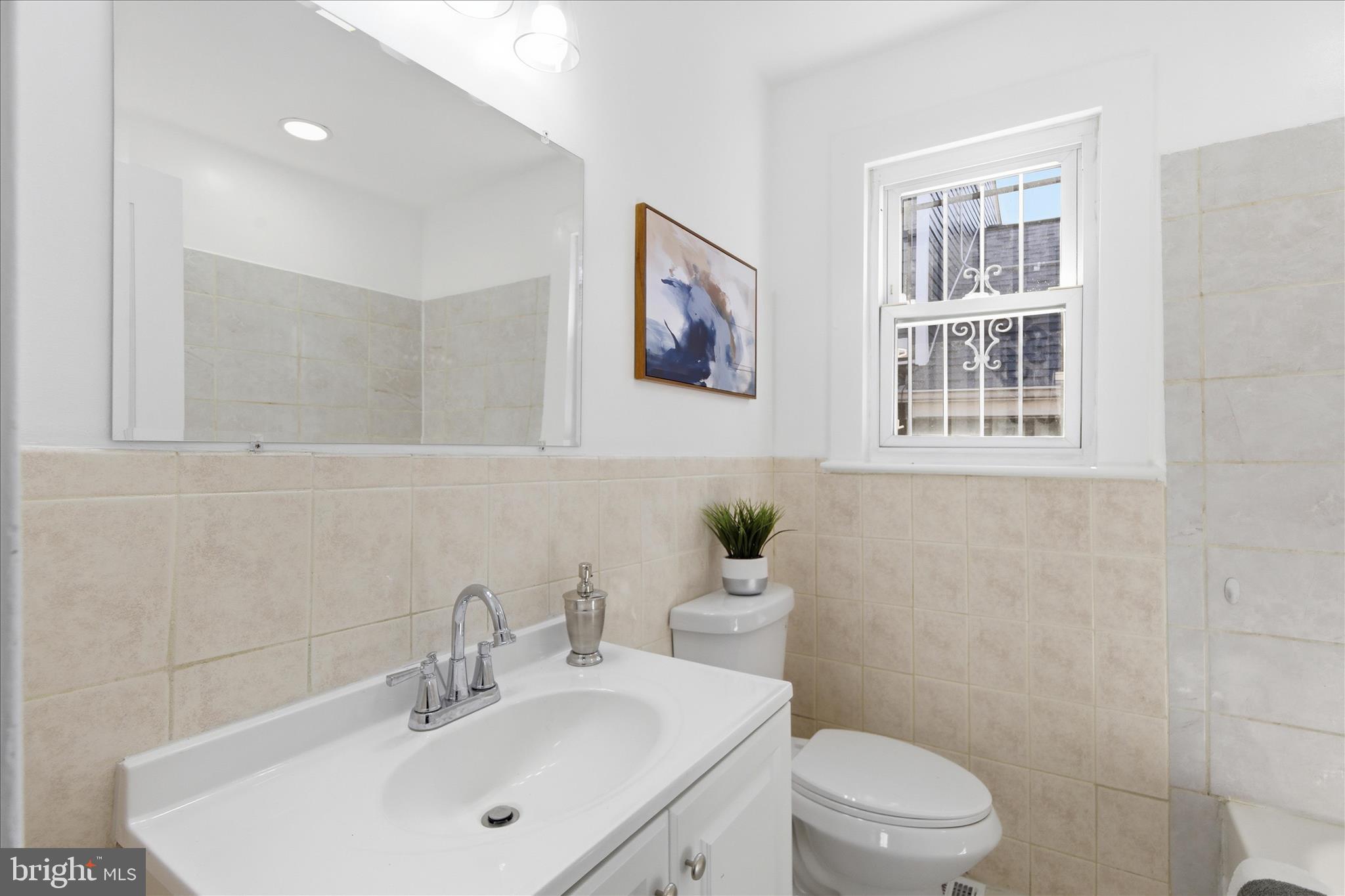 4029 Gault Place Northeast Washington, DC 20019 - Photo 18 of 33 a bathroom with a toilet a sink a mirror and a shower