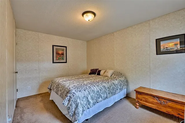 a bedroom with a bed and painting on the wall