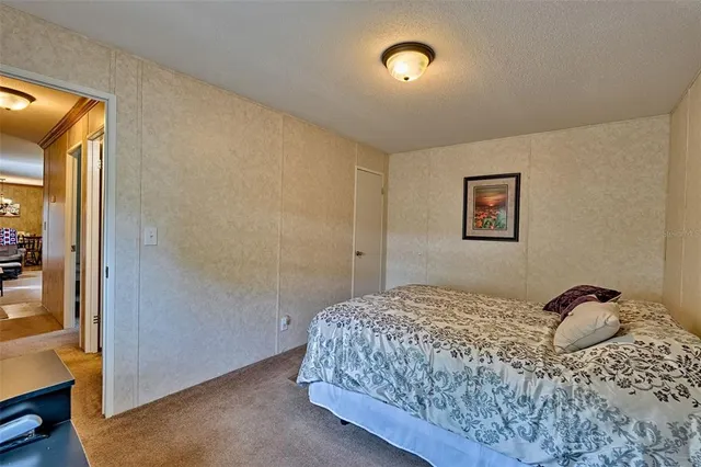 a bedroom with a bed and a painting on the wall