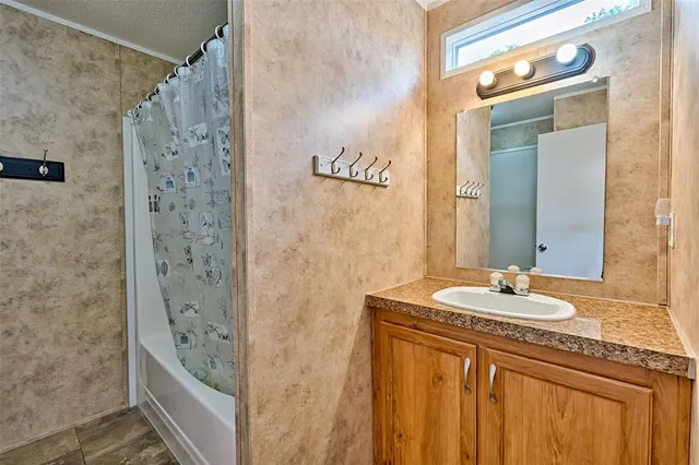a bathroom with a granite countertop sink a mirror a shower and a bathtub