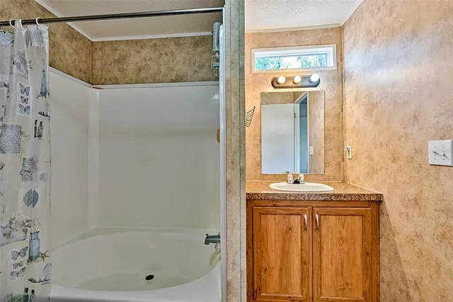 a bathroom with a shower and a sink