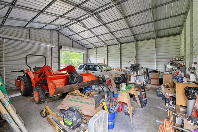 a backyard of a house with plants and large tree