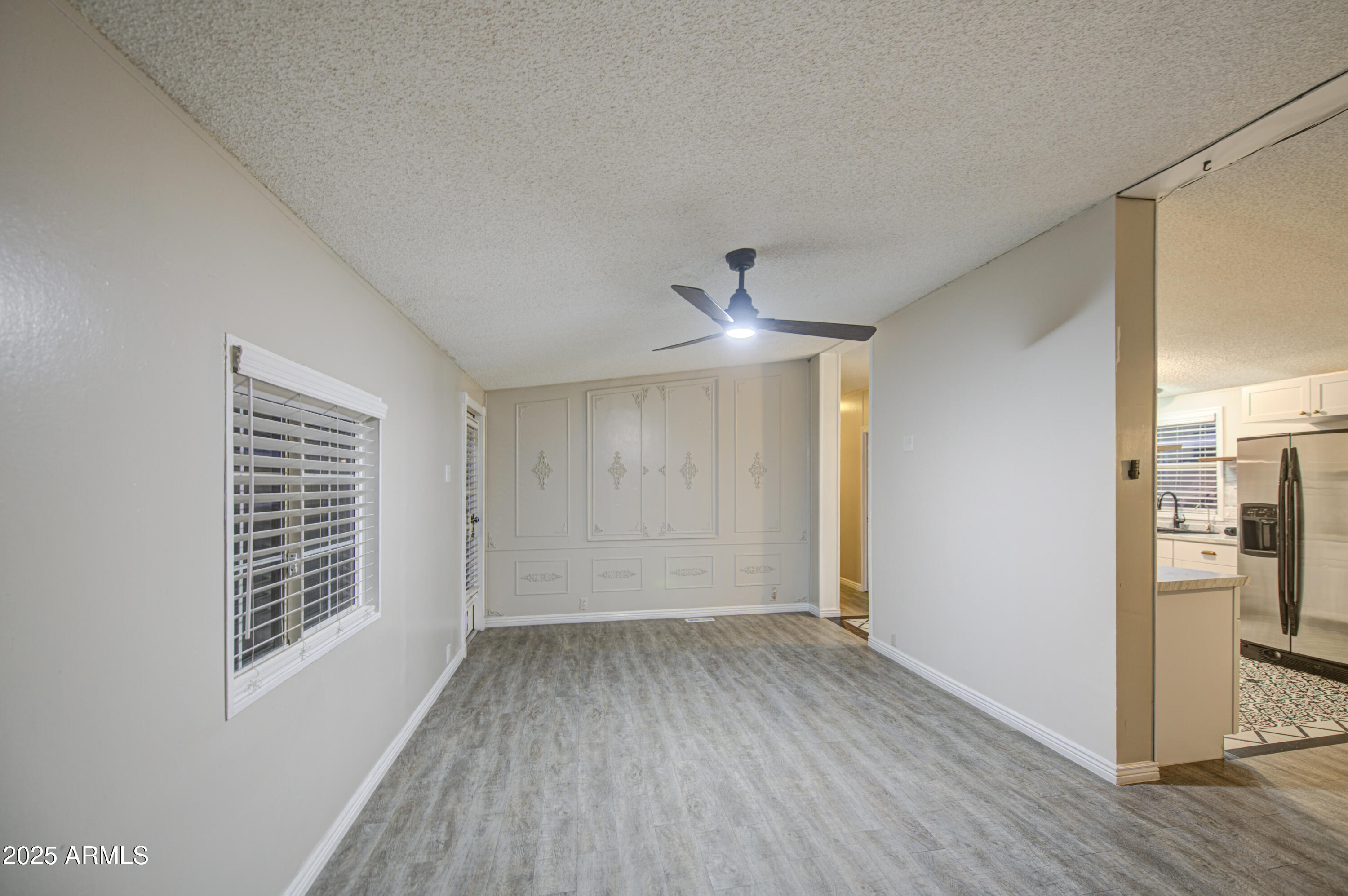 19401 North 7th Street, Unit 94 Phoenix, AZ 85024 - Photo 9 of 12 a view of empty room with wooden floor and fan