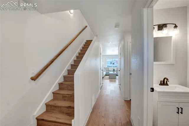 a view of a hallway with wooden floor and staircase