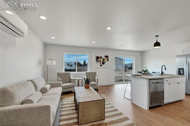 a living room with furniture and view of kitchen