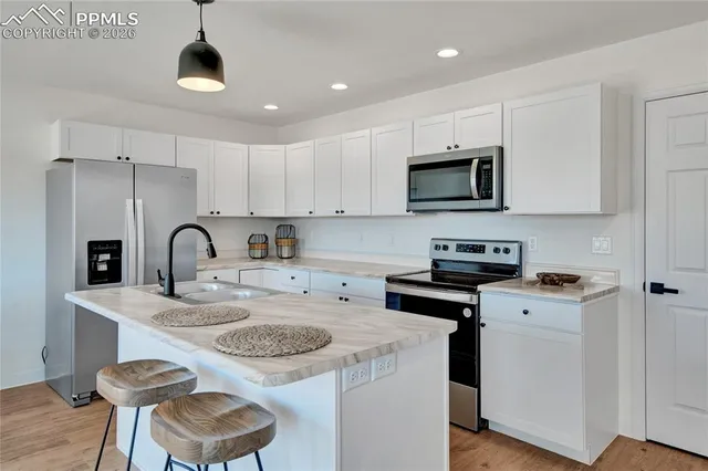 a kitchen with a sink a stove and a microwave