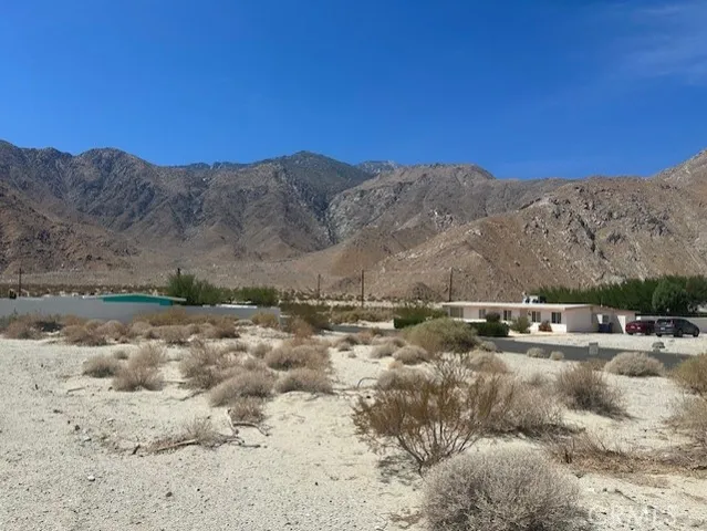 a view of a dry yard with mountains in the background