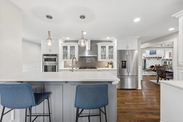 a large kitchen with stainless steel appliances kitchen island granite countertop a table and chairs in it