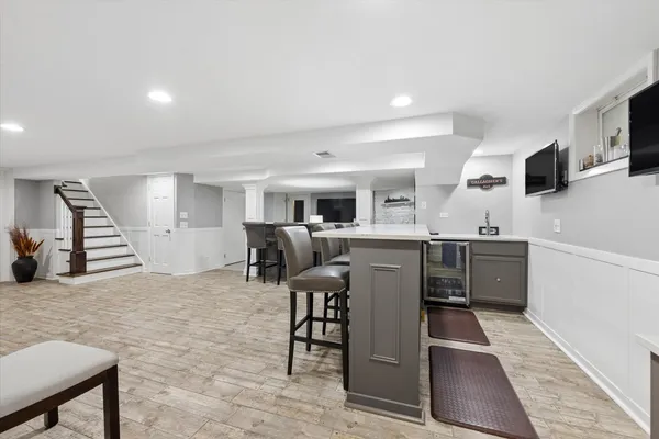 a living room with furniture a flat screen tv and kitchen view