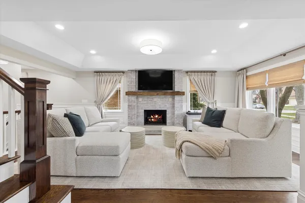 a living room with furniture a flat screen tv and a fireplace
