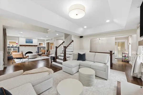 a living room with furniture kitchen view and a wooden floor