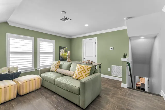 a living room with stainless steel appliances furniture a chandelier a rug and a window