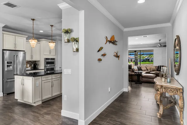 a kitchen with stainless steel appliances a stove a refrigerator and a view of living room