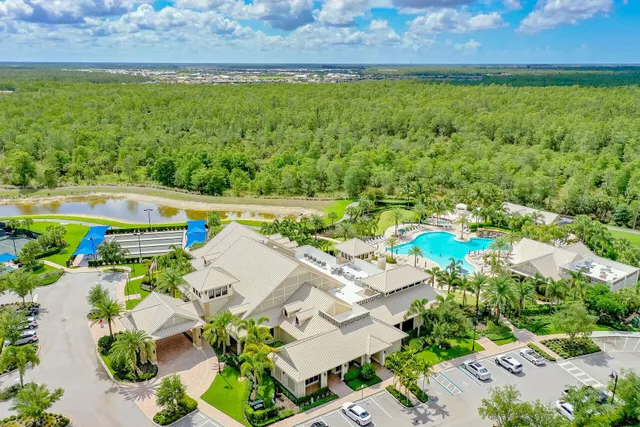 a room with lots of tables a large window and chairs