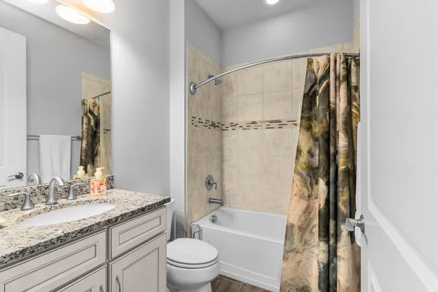 a bathroom with a granite countertop sink toilet and shower