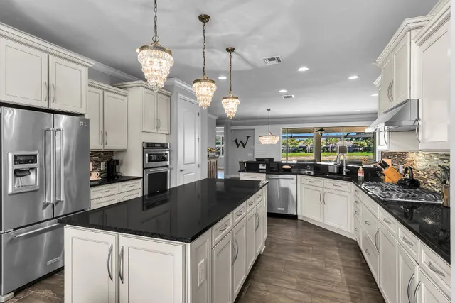a kitchen with a sink a counter top space stainless steel appliances and cabinets
