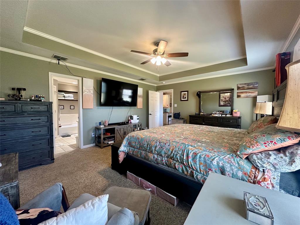 10504 Whitney Trace Drive Waco, TX 76708 - Photo 14 of 36 a spacious bedroom with a bed and a flat screen tv