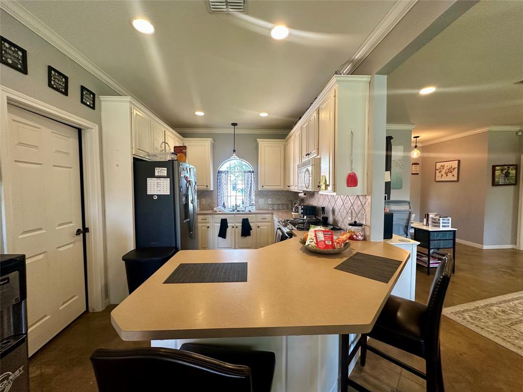 10504 Whitney Trace Drive Waco, TX 76708 - Photo 10 of 36 a kitchen with stainless steel appliances a dining table chairs refrigerator and sink