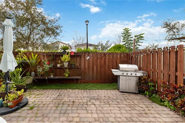 a view of a patio with table and chairs potted plants