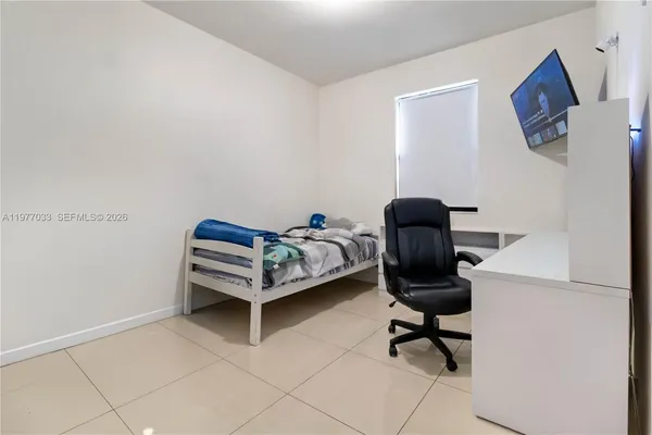 a bedroom with a chair and a desk