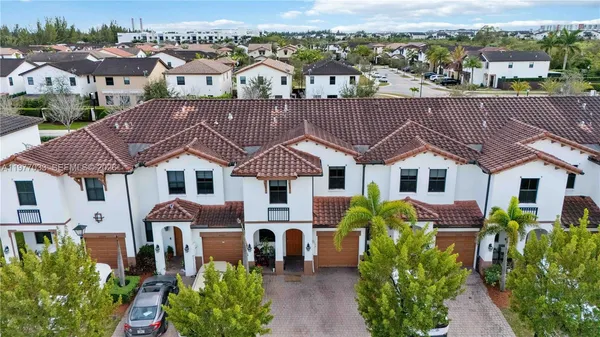 an aerial view of multiple houses with a yard