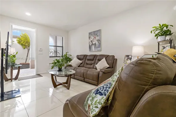 a living room with furniture and a potted plant