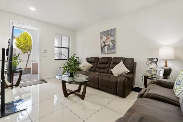 a living room with furniture and a potted plant