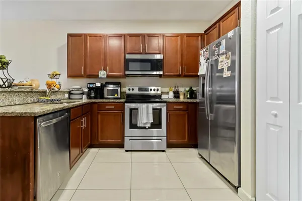 a kitchen with stainless steel appliances granite countertop a stove top oven and refrigerator